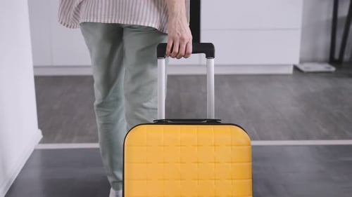 An Unrecognizable Woman with a Yellow Suitcase Arrived at the Rented Apartment
