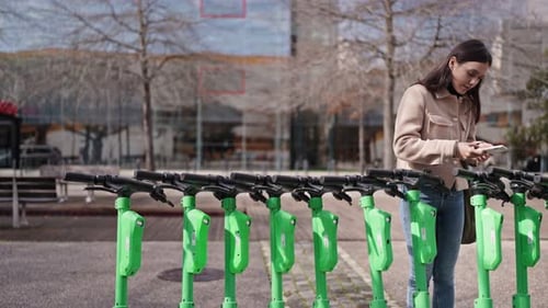 Young Woman Renting Electric Scooter in Urban Area