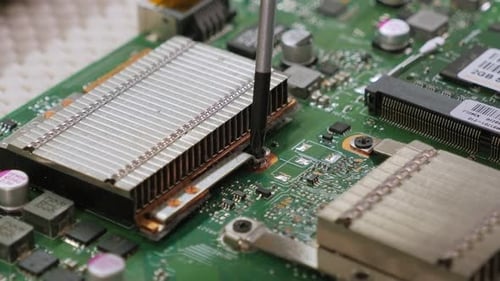 Young Male Tech or Engineer Repairs Electronic Equipment in Research Facility