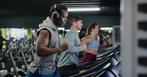 Headphones, fitness and man on treadmill in gym for running, workout or training with health