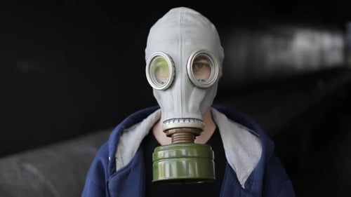 Porträt einer Frau mit Gasmaske, die in die Kamera blickt