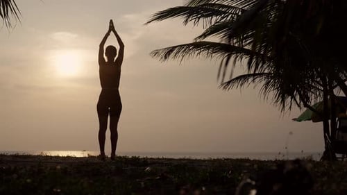 Frau praktiziert Yoga auf dem Meer bei Sonnenuntergang Silhouette Sportliches Yoga-Mädchen macht Yoga-Pose Asana-Übung