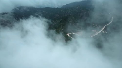 Aerial View The sky is cloudy and the mountains and road are covered in fog