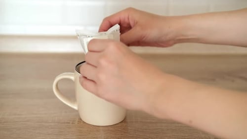 Hands Making Coffee in Beige Mug in Home