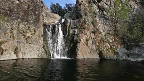 A Distant View of the Waterfall Flowing From The Rocks