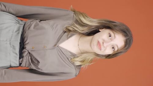 Young Woman in Brown Button Down Against Orange
