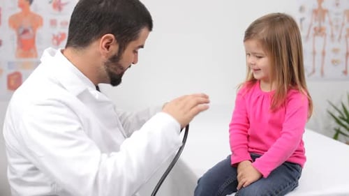 Pediatrician with Child in Doctor'S Office Bed