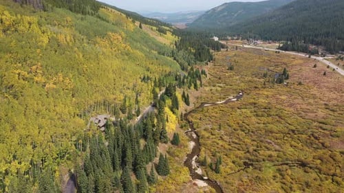 Scenic landscape of Colorado USA on sunny fall day. Aerial view of aspen forest countryside road and