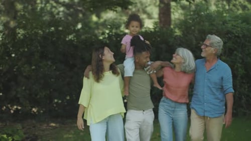 Happy Multigenerational Family Walking and Smiling in the Park