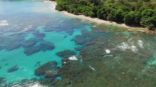 Aerial view of turquoise reef lagoon and sandy tropical shoreline in Costa Rica