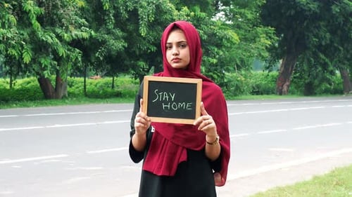 Young Woman Holding Stay Home Sign Near Road