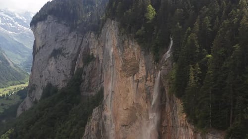 Jib up of stunning waterfall pouring of high mountain