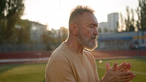 Adult Man Rubbing Hands Together at Sunset