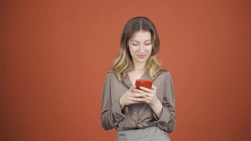 Happy young woman texting on the phone. Smiling.