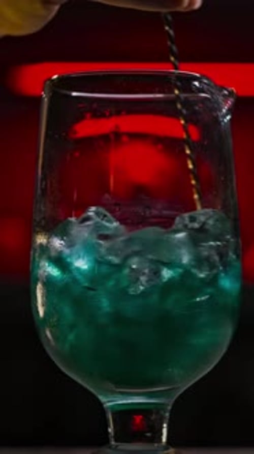 Stirring a Shimmery Blue Cocktail Close Up