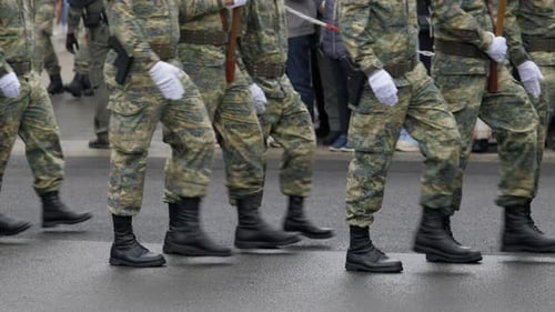 Servicemen Walk in Formation Against Spectators Crowd
