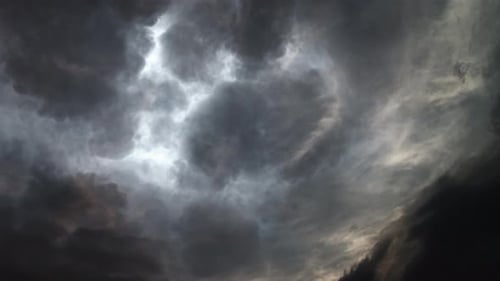 Gewitter und dunkle Wolken, die sich am dunklen Himmel bewegen.
