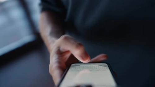 Person Typing on Smartphone in Dark Home Setting