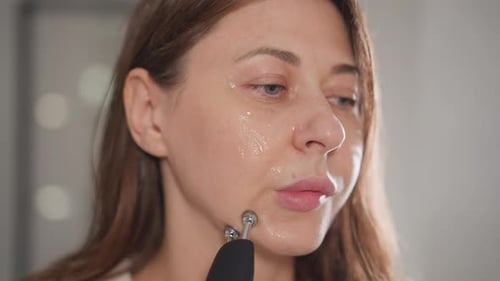 Woman Using Beauty Device on Face