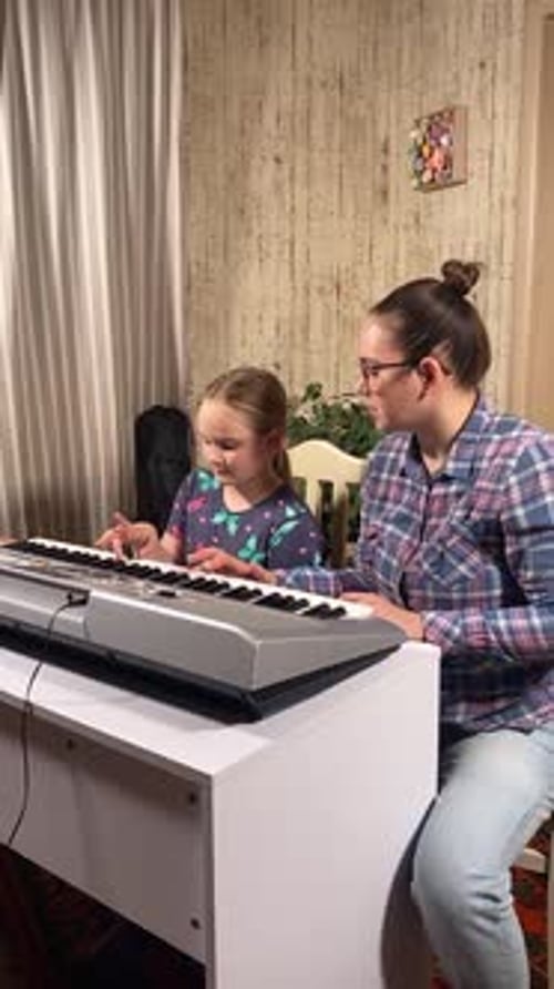Child and Woman Playing Keyboard in Home Setting