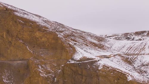 video shot of a rocky mountain pass covered with snow surrounded