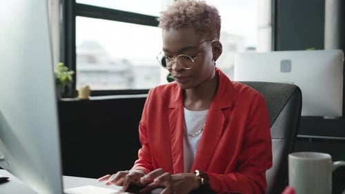 A Focused and Dedicated Professional Working on a Computer in a Modern Office Environment