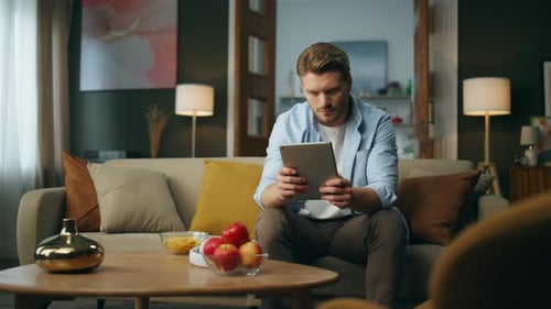 Man using Tablet at Home on Sofa