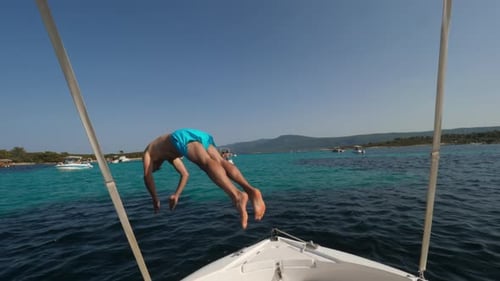 Man Jumps Off Boat into Tropical Blue Water