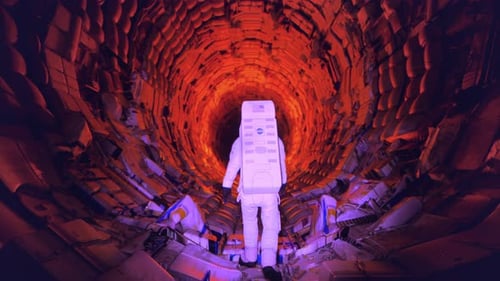 Astronaut walks through rubble tunnel
