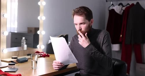 Actor with script rehearsing his lines in dressing room