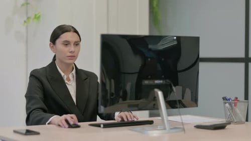 Businesswoman at Desk Gives Thumbs Down