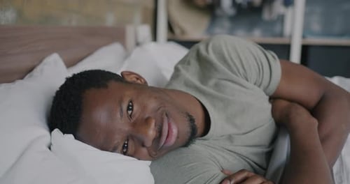 Handsome Man Smiling Lying in Bed at Home