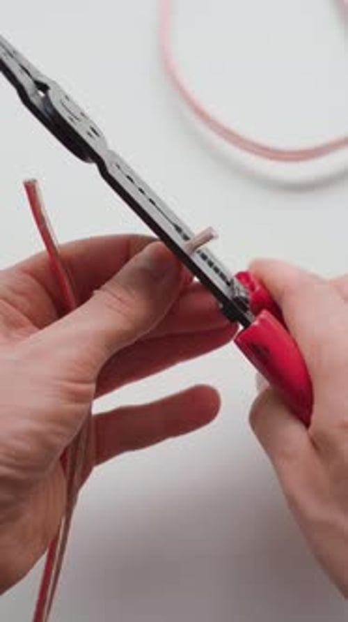 Man stripping two wires with wire strippers. Close up