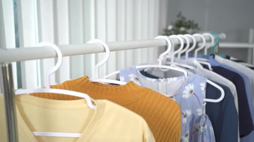 Rack of Colorful Clothes Hanging in Closet