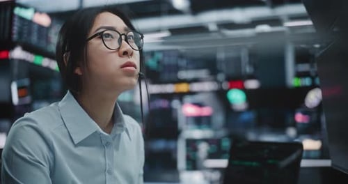 Focused Businesswoman Operates at Multi Monitor Workstation in Modern Stock Exchange Hub