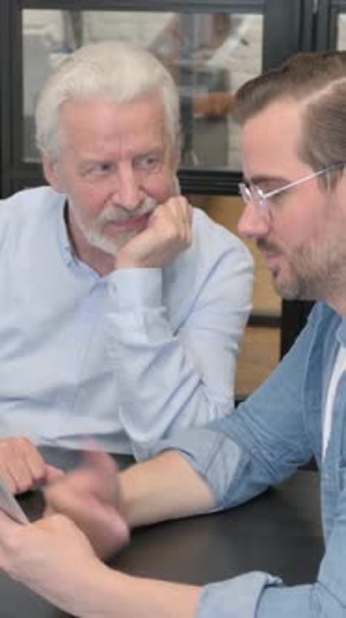 Senior Man Video Calling with Younger Adult Friend