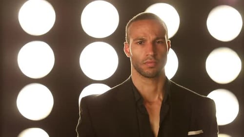 Handsome and stylish man in front of a wall of lights