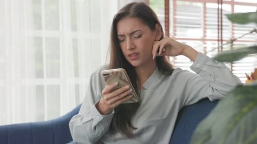 Woman Using Smartphone in Home Thinking