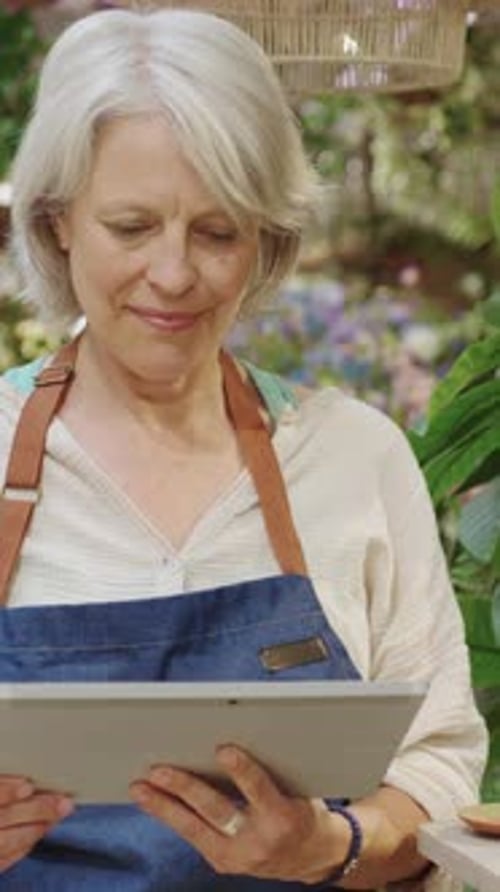Florist Using Digital Tablet in Flower Shop in Slow Motion