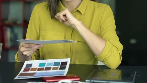 Young woman designer choosing color samples for a project at her home office
