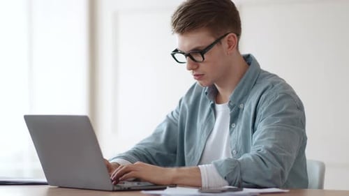 Man Working at Laptop in Bright Interior