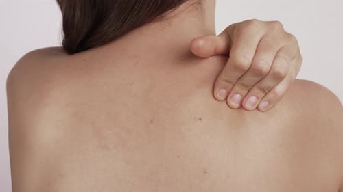 Woman Rubbing Her Shoulder and Upper Back