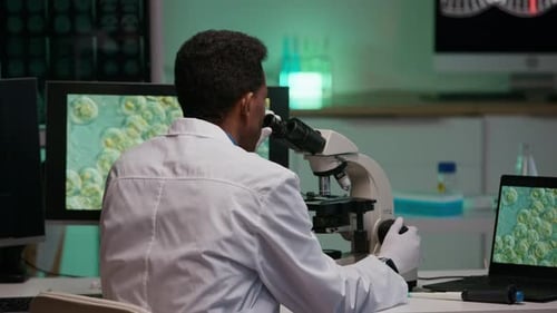 Scientist Uses Microscope in Laboratory Setting