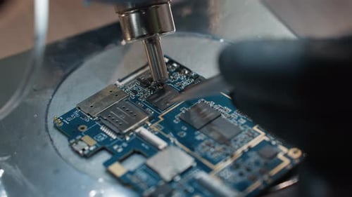 Technician Working on Circuit Board Under Microscope CloseUp View