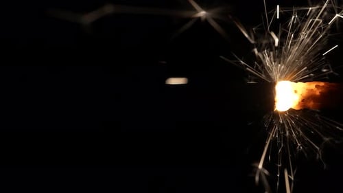 Burning Sparkler with Golden Sparks on Black