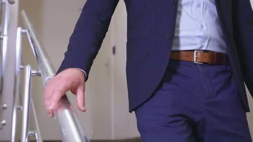 Man Walks Down Interior Staircase in Business Attire
