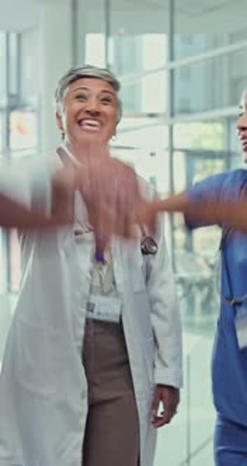 Doctor, team and hands together for celebration, success and goal achievement in hospital