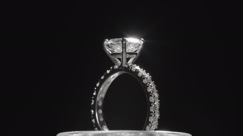 Wunderschöner Diamantring, der sich vor einem schwarzen Studiohintergrund dreht