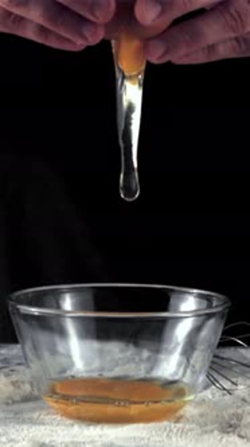Las manos de los cocineros en cámara superlenta rompen el huevo para hornear filmado con una cámara de alta velocidad a 1000 fps
