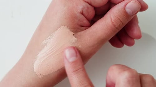 Woman Tests Beige Liquid Foundation on Hand